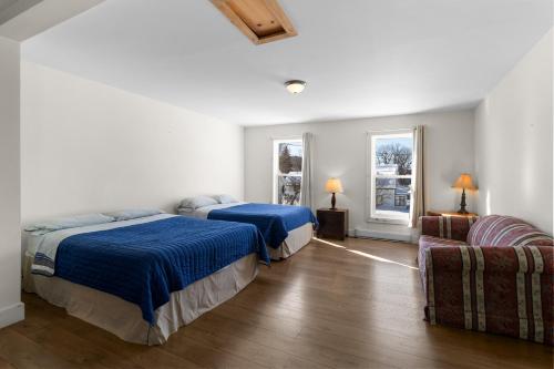 ein Schlafzimmer mit zwei Betten und einer Couch in der Unterkunft Usine Stanstead in Beebe