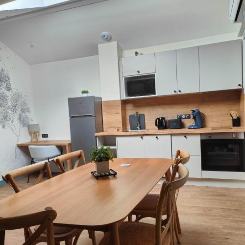 une cuisine avec une table et des chaises en bois dans l'établissement Les appart'hotels de la fontaine, à Autoire