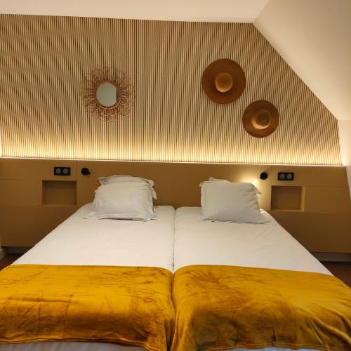 - une chambre avec 2 lits avec des draps jaunes dans l'établissement Les appart'hotels de la fontaine, à Autoire