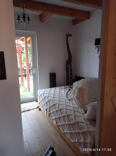 ein Schlafzimmer mit einem Bett in einem Zimmer mit Fenster in der Unterkunft Domek BOHO in Rydzewo