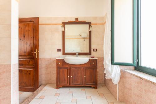 a bathroom with a sink and a mirror at La Casa Rosa Di Rita E Franco in Scano Montiferro