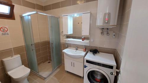 a bathroom with a washing machine and a sink at Blackwood Flava Cora in Datca