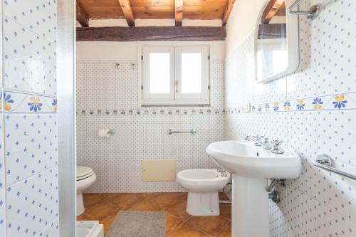 un bagno con lavandino e WC di Il Palazzo Storico a Bosa