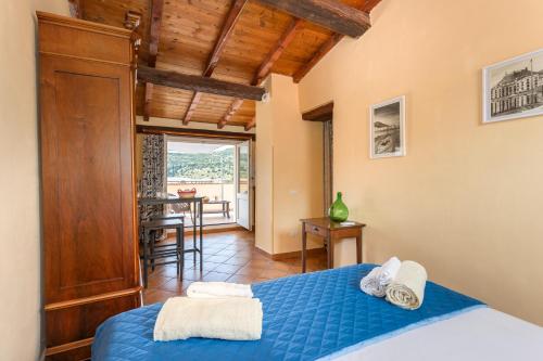 una camera con letto blu e una sala da pranzo di Il Palazzo Storico a Bosa