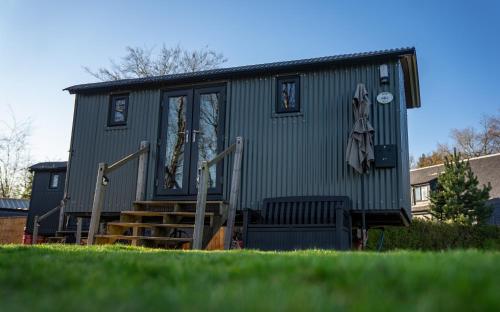 a green tiny house with stairs in a yard at Loch Lomond Waterfront Luxury Lodges in Balmaha