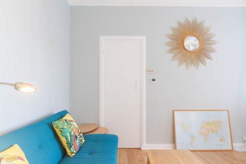a living room with a blue couch and a mirror at Chic 1 Bed Studio Flat in Popular Bloomsbury in London