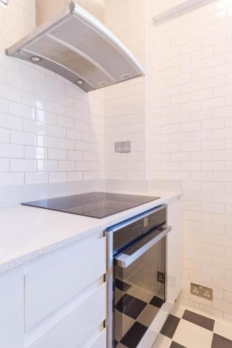 a kitchen with a sink and a stove at Chic 1 Bed Studio Flat in Popular Bloomsbury in London