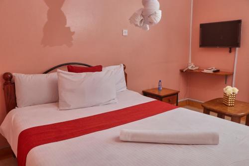 a bedroom with a bed with a red and white blanket at 136 Boutique Address Hotel in Nairobi