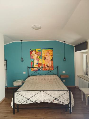 a bedroom with a bed with a blue wall at La casa sul tetto, Room's & Glamping in Recanati