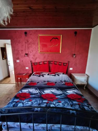 a bedroom with a bed with a red wall at La casa sul tetto, Room's & Glamping in Recanati
