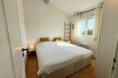 une chambre blanche avec un lit et une fenêtre dans l'établissement Esprit du Sud Les 4 Mousquetaires, à Roquebrune-sur Argens