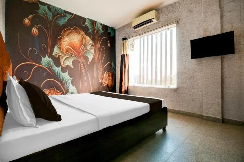 Un dormitorio con una cama con un cuadro en la pared. en Hotel O EB Hotel, en Amritsar