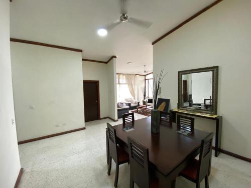 a dining room with a table and chairs and a mirror at Apartment Comfortable in Urdesa in Guayaquil