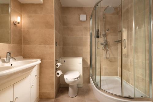a bathroom with a shower and a toilet and a sink at Moor Hall Hotel & Spa in Sutton Coldfield