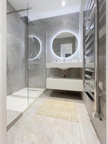 une salle de bain avec un lavabo et un miroir dans l'établissement Superbes prestations terrasse piscine mer 350L, à Cannes