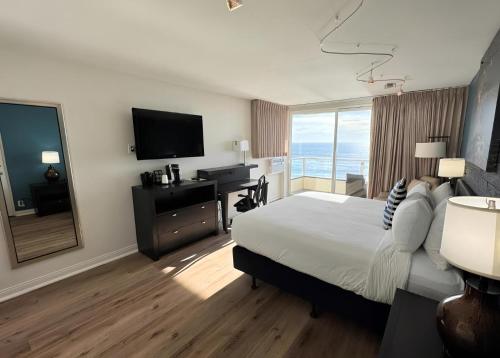 a hotel room with a bed and a desk and a television at Pacific Edge Hotel in Laguna Beach