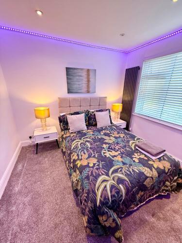 a bedroom with a large bed with purple walls at 1 bed modern apartment walking distance from shopping mall in Golders Green