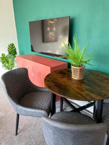 a table with two chairs and a table with a plant on it at 1 bed modern apartment walking distance from shopping mall in Golders Green