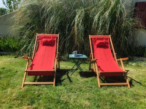 two deck chairs and a table in the grass at Au 10 le long du canal in Fain-lès-Montbard