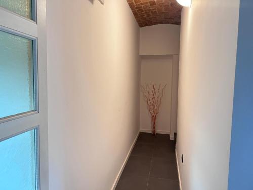a hallway with a white wall and a window at Lory Smart - Relax e Natura by RD Domus in Moncalieri