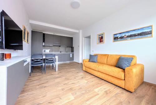 a living room with a couch and a kitchen at Appartamento Le Rondini B in Pianello Del Lario