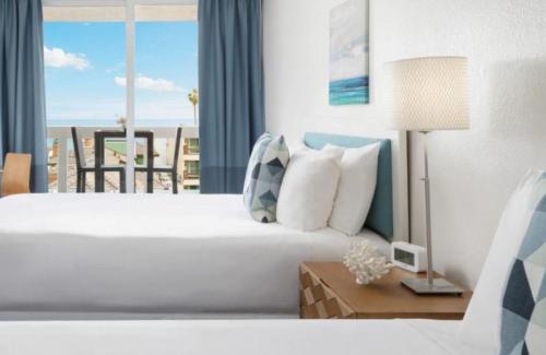 a bedroom with a bed with a view of the ocean at Pacific Edge Hotel in Laguna Beach