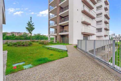 an apartment building with a green yard in front of it at Airy Apartments with Balcony & Garage in Milan