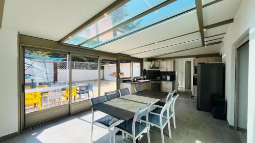 une cuisine et une salle à manger avec une table et des chaises dans l'établissement Maison Hirondelles, piscine mer et forêt, à Saint-Jean-de-Monts