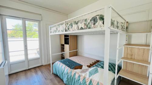 une chambre avec un lit superposé et une fenêtre dans l'établissement Maison Hirondelles, piscine mer et forêt, à Saint-Jean-de-Monts