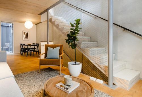 a living room with a couch and a stair case at Urban Oasis - Spacious 3BR Townhouse w Terrace in Wellington