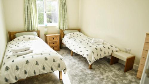a bedroom with two beds and a window at 3BD Gem in the Heart of Barnetby Le Wold in Barnetby le Wold