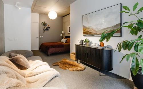 a living room with a couch and a bed at Urban Oasis - Spacious 3BR Townhouse w Terrace in Wellington