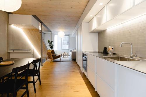 a kitchen with white cabinets and a table and chairs at Urban Oasis - Spacious 3BR Townhouse w Terrace in Wellington