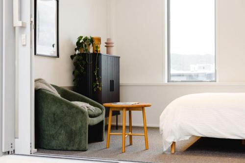 a bedroom with a green couch and a table at Urban Oasis - Spacious 3BR Townhouse w Terrace in Wellington