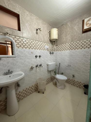 a bathroom with a sink and a toilet at Sharda House in Manāli