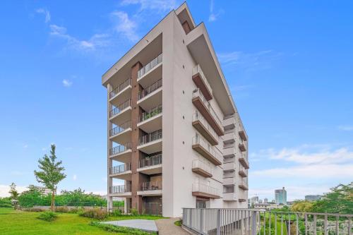 a tall apartment building with a green yard at Airy Apartments with Balcony & Garage in Milan