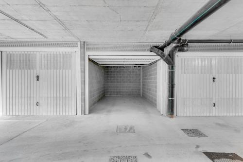 an empty garage with white walls and doors at Airy Apartments with Balcony & Garage in Milan