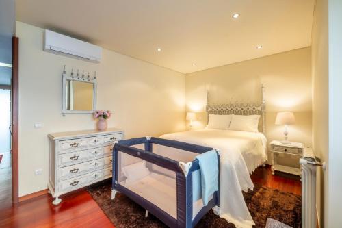 a bedroom with a bed and a dresser and a mirror at Panoramic City View Apartment - Guimarães in Guimarães