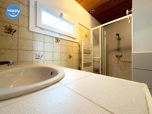 La salle de bains est pourvue d'une baignoire blanche et d'une fenêtre. dans l'établissement Alice Proche Grotte Salamandre & Aven d'Orgnac, à Saint-Jean-de-Maruéjols-et-Avéjan