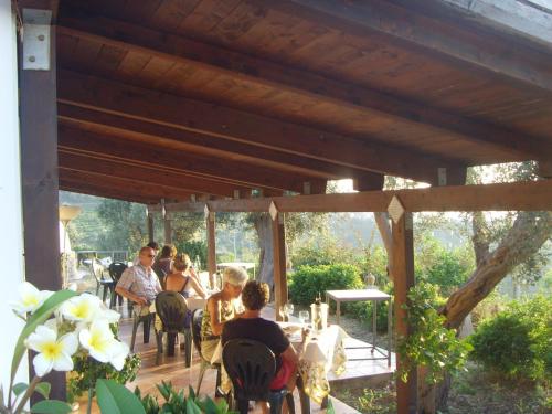 a group of people sitting at a table on a deck at Giardino Di Sicilia in SantʼAgata di Militello