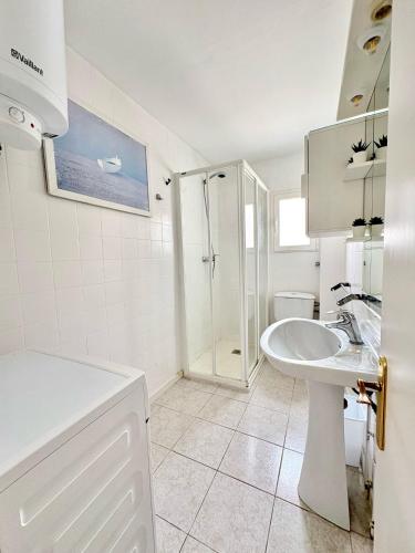 a white bathroom with a sink and a shower at Apartamentos Formentera Copacabana 18 in Es Pujols