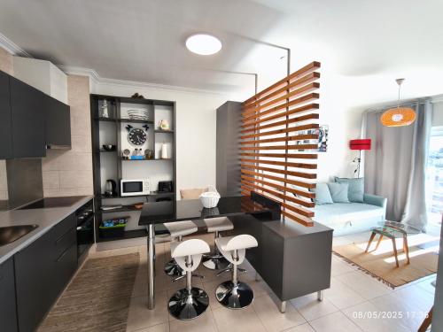 a kitchen and living room with a table and chairs at Apartamento Jeni Residencia Flamingo in Portimão