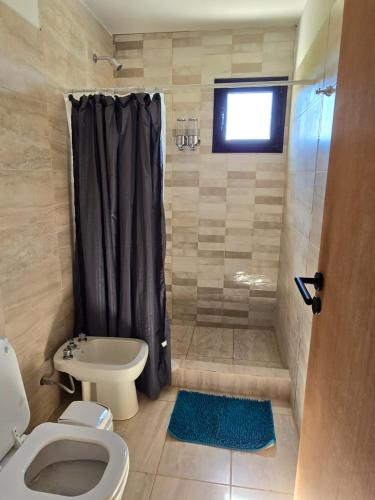 a bathroom with a shower with a toilet and a sink at Gaviotas del Sur in Potrero de Garay