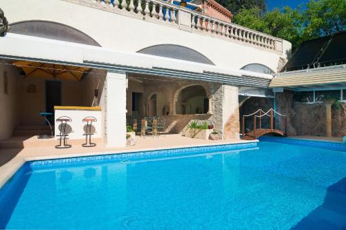 a swimming pool in front of a house at B&B Le Logis Du Mas in Sète