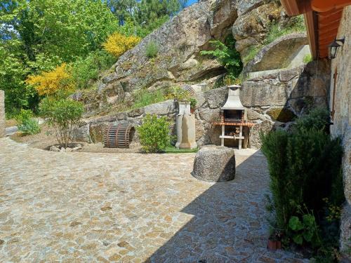 a stone wall with a stove in a yard at Casa da Fragoeira in Gandarela