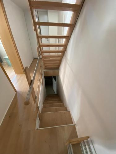 a staircase in a house with a wooden railing at Michelles FeWo in Uttenweiler
