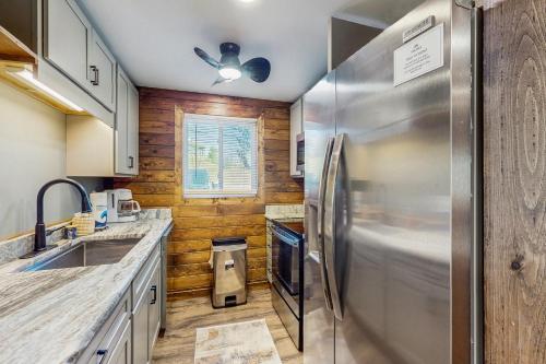 a kitchen with a stainless steel refrigerator and wooden walls at Ski Cove #2 in McHenry