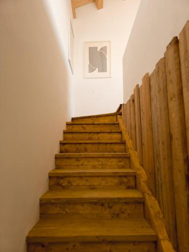 a stairway with wooden steps in a building with a painting at Il portiot di Langa - Ijan Ospitalità di Borgata in Igliano