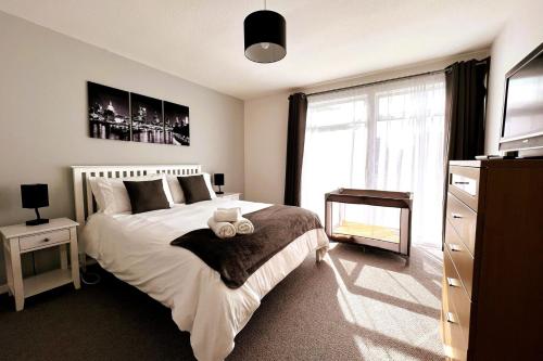 a bedroom with a bed with a teddy bear on it at Spacious Family Bungalow with Garden for up to 7 in Epsom