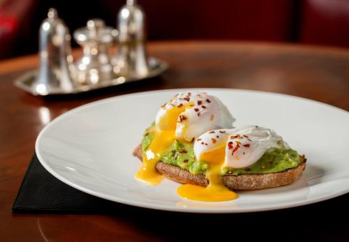 a white plate with an egg sandwich on a table at The Stafford London in London